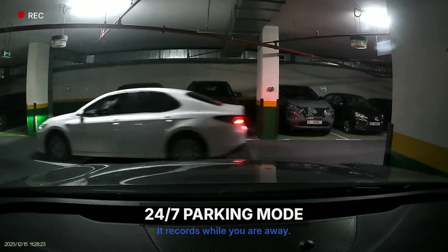 LYNX parking-mode capture in an underground car park — a white saloon moving past the parked vehicle the camera is fitted to.